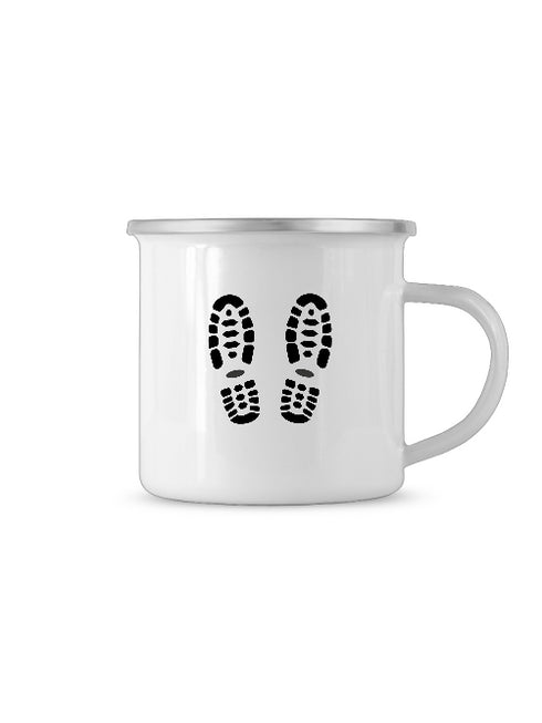 Auf dieser weißen Tasse oder Becher befindet sich ein dunkler Abdruck von Wanderschuhen oder Arbeitsschuhen.